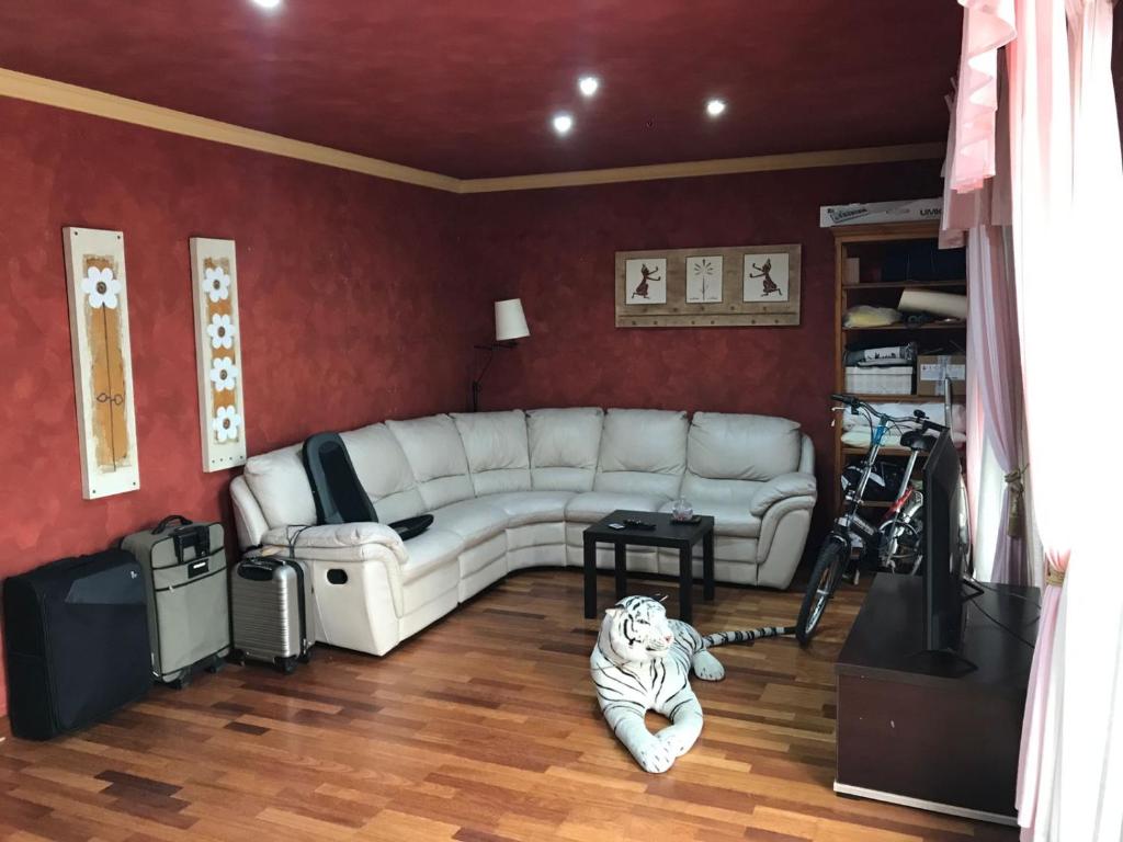 福恩吉罗拉Los Girasoles的客厅铺有白色沙发,配有老虎。