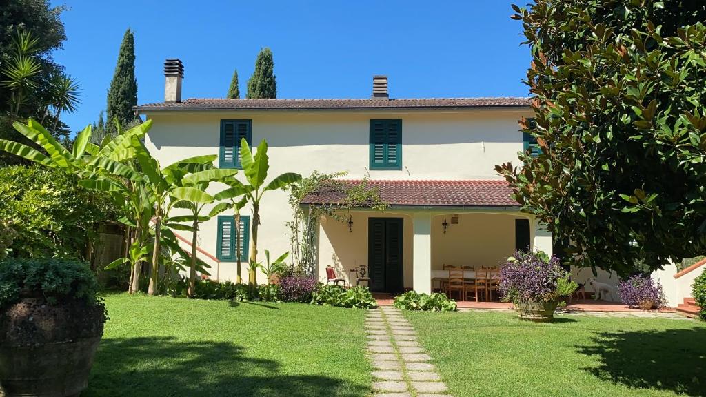 博尔格阿布贾诺Casa del Pino的白色的房子,有蓝色百叶窗和院子