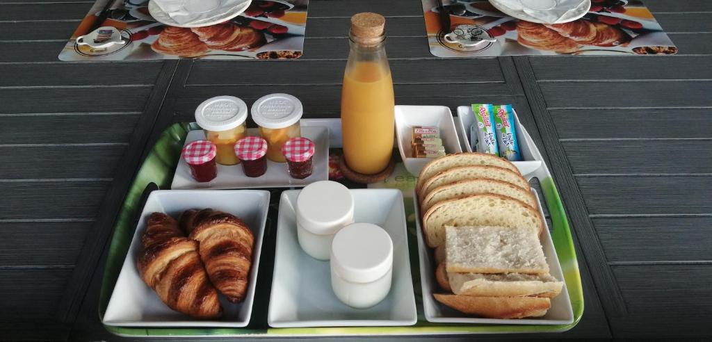 LantosqueMon gîte à Pélasque的包括面包和糕点以及1瓶橙汁的午餐盒