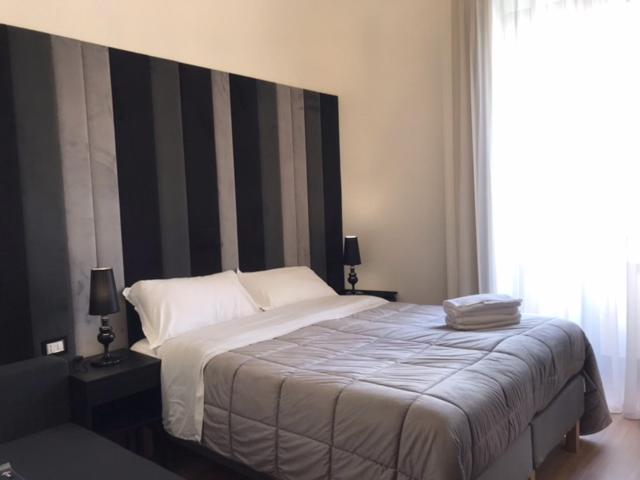 莫塔·圣塔纳斯塔西亚Motta Palace Apartments & Rooms的一间卧室配有一张带黑白床头板的床