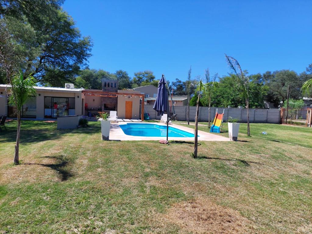 圣地亚哥-德尔埃斯特罗Finca La Candelaria的后院设有游泳池和遮阳伞