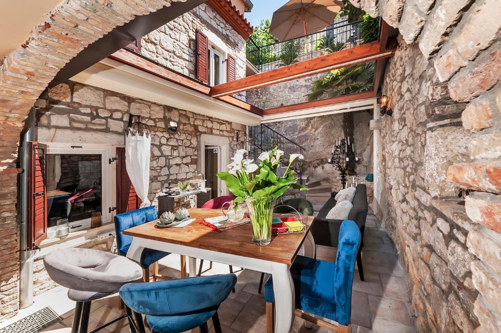 罗维尼Luxury Villa Orh Rovinj的一间带桌子和蓝色椅子的用餐室