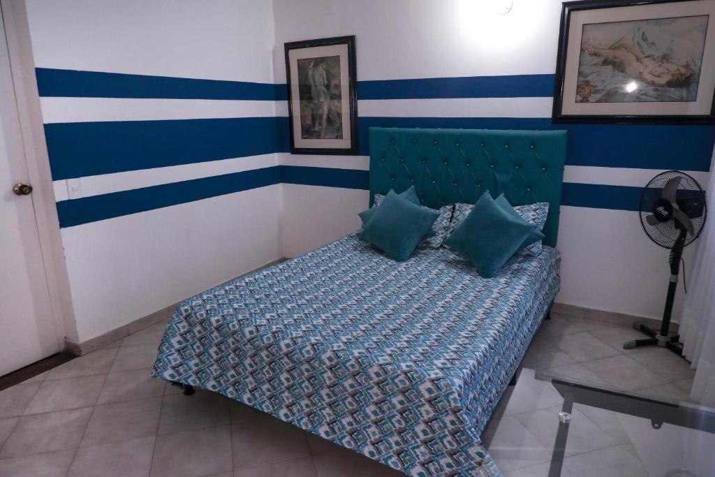 麦德林Casa La Palma Habitación Cielo的一间卧室配有一张蓝色和白色条纹的床