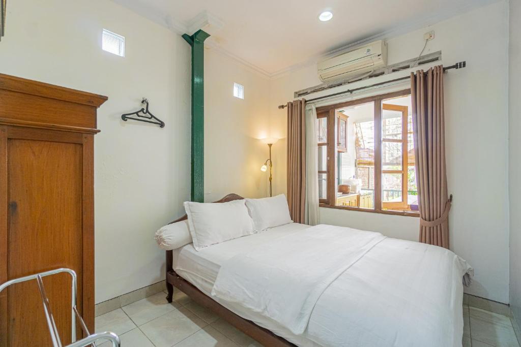 日惹奥玛吉尔恩29布克特维斯塔公寓的卧室配有白色的床和窗户。