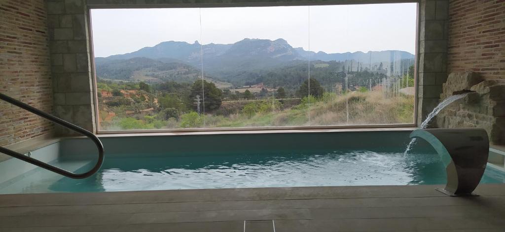 BotHotel & Spa Can Josep的浴缸设有大窗户,享有山景