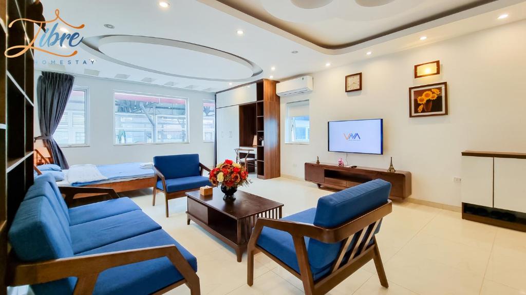 河内Libré Homestay Đào Tấn的客厅配有蓝色椅子和沙发