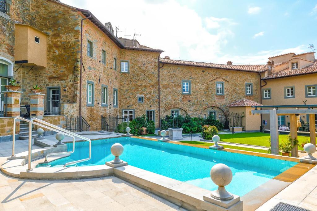 科尔托纳Monastero Di Cortona Hotel & Spa的建筑前带游泳池的庄园