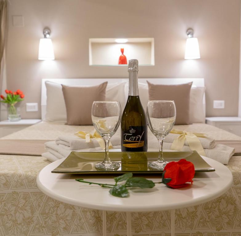 那不勒斯Reginella Duomo Apartment的桌子上一瓶葡萄酒和两杯