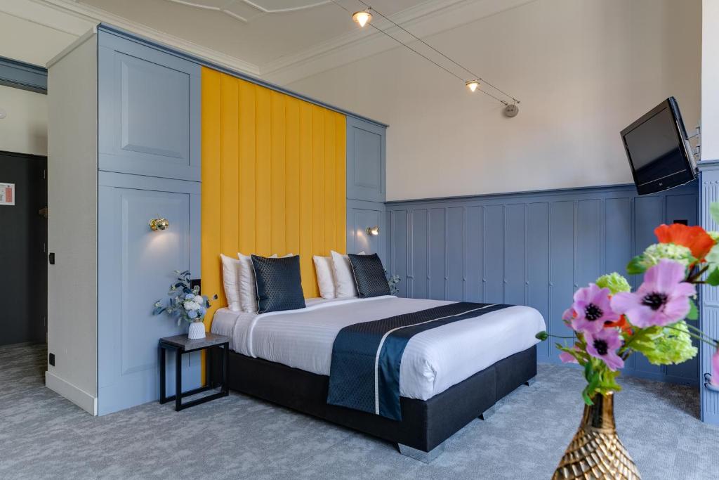 代尔夫特皇家桥酒店的配有一张床和花瓶的酒店客房