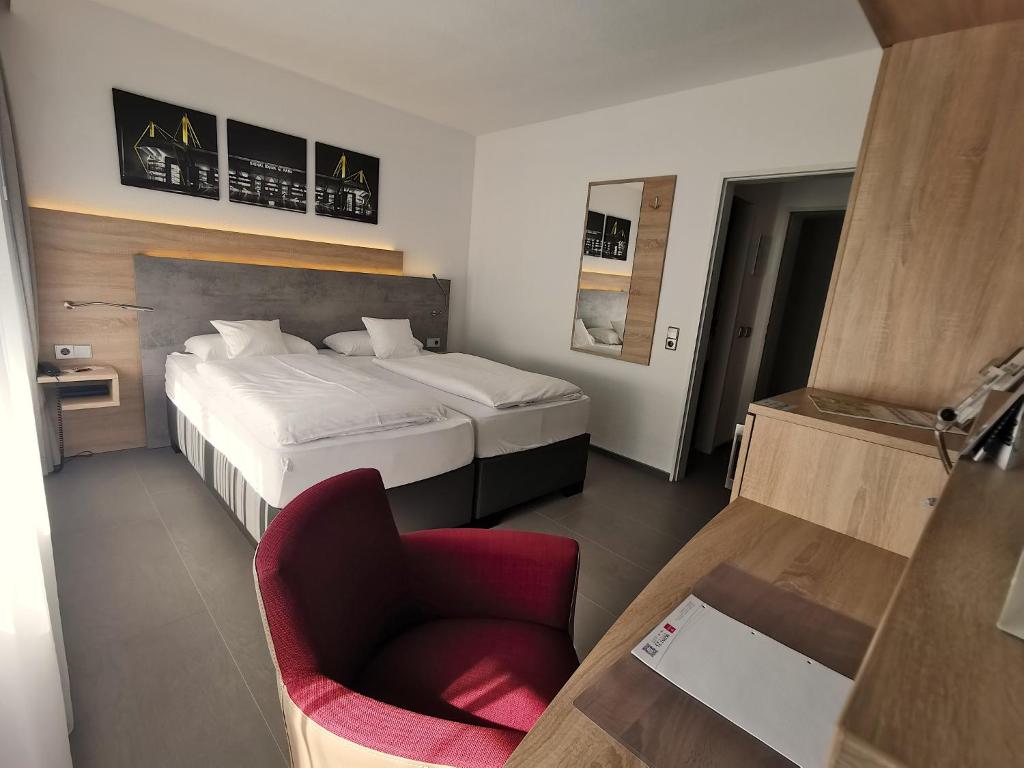 多特蒙德科奈尔阿卡森特酒店的配有一张床和一把椅子的酒店客房
