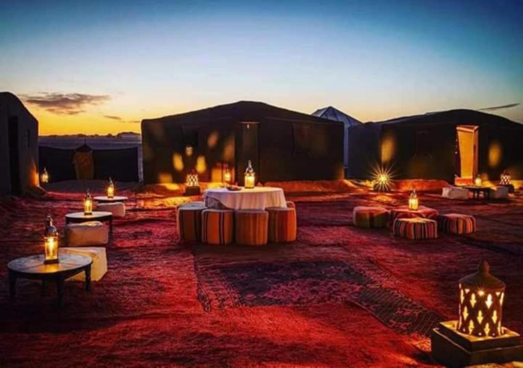 姆哈米德Bivouac de luxe Mhamid的沙漠中带桌子和蜡烛的房间