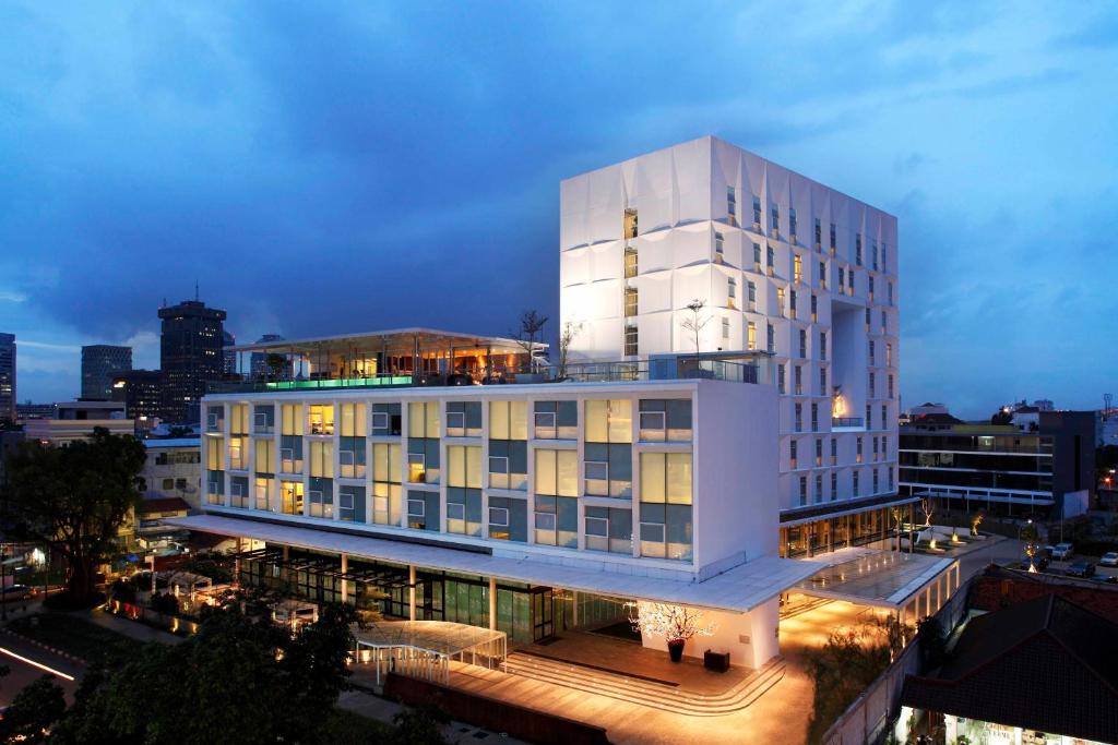 雅加达莫里西公寓式酒店的一座白色的大建筑,外墙有灯光