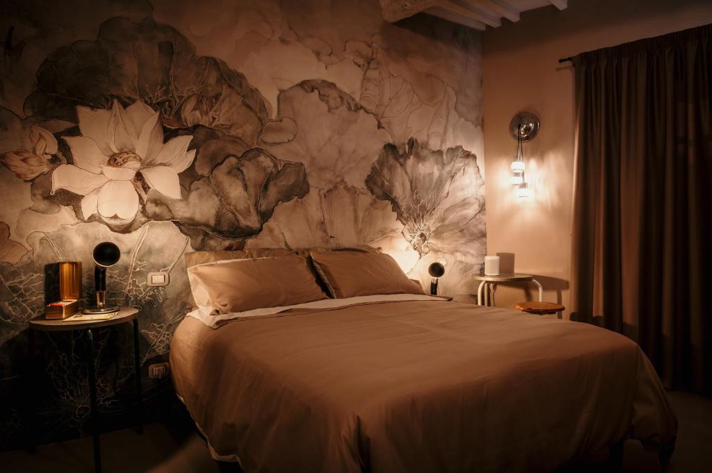 阿巴迪亚圣萨尔瓦托雷B&B La Castellina的一间卧室设有一张带花卉墙壁的大床