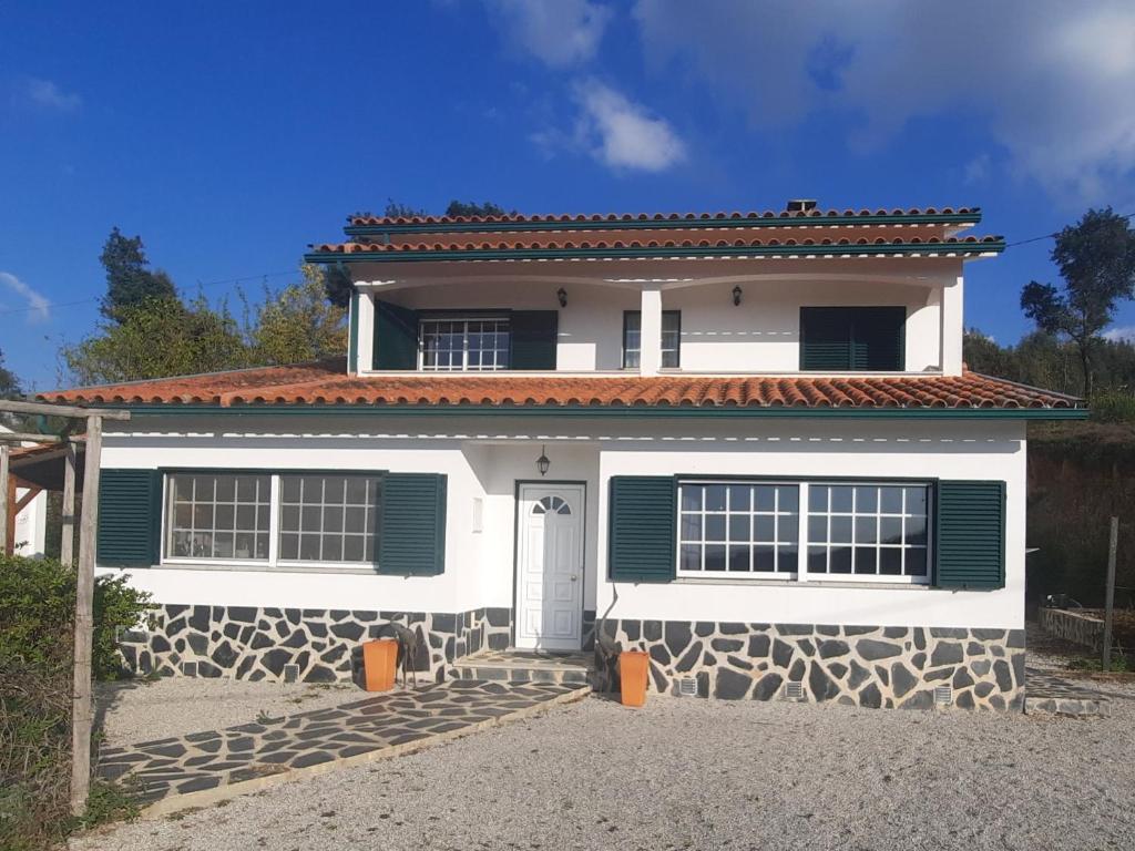 AncerizCasa-Estaro的白色的房子,上面有绿色百叶窗