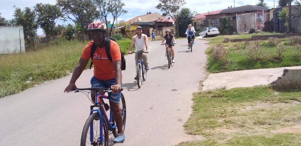 索韦托Authentic Bicycle Tours and Backpackers的一群人骑着自行车沿着马路