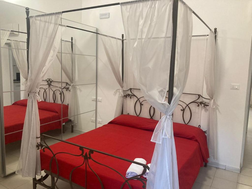 佩斯卡拉Casa Vacanze Mare的一间卧室配有两张带红色床单和天蓬的床