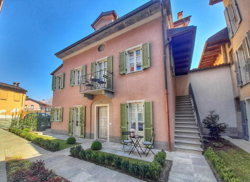 坎诺比奥Alessia Home的粉红色的房子,设有绿色百叶窗和楼梯