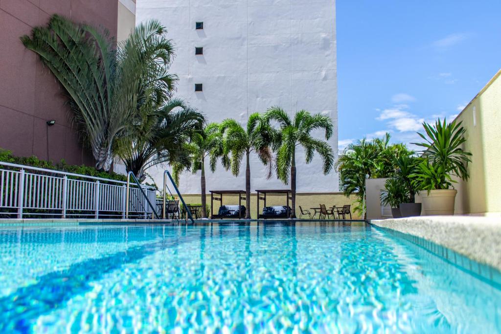 库亚巴代尔蒙酒店的一座棕榈树游泳池和一座建筑
