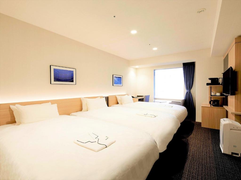 东京Tmark City Hotel Tokyo Omori - Vacation STAY 26425v的酒店客房设有两张床和窗户。