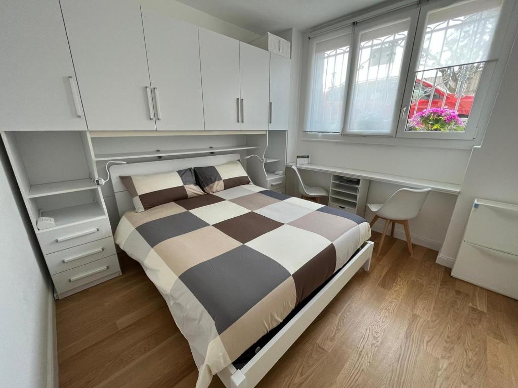 米兰The Small White House In Milan的一间卧室配有一张床、一张书桌和一个窗户。