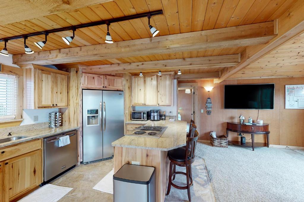 西塞德Cozy on the Coast的一间带木制天花板的厨房和一间带柜台的厨房