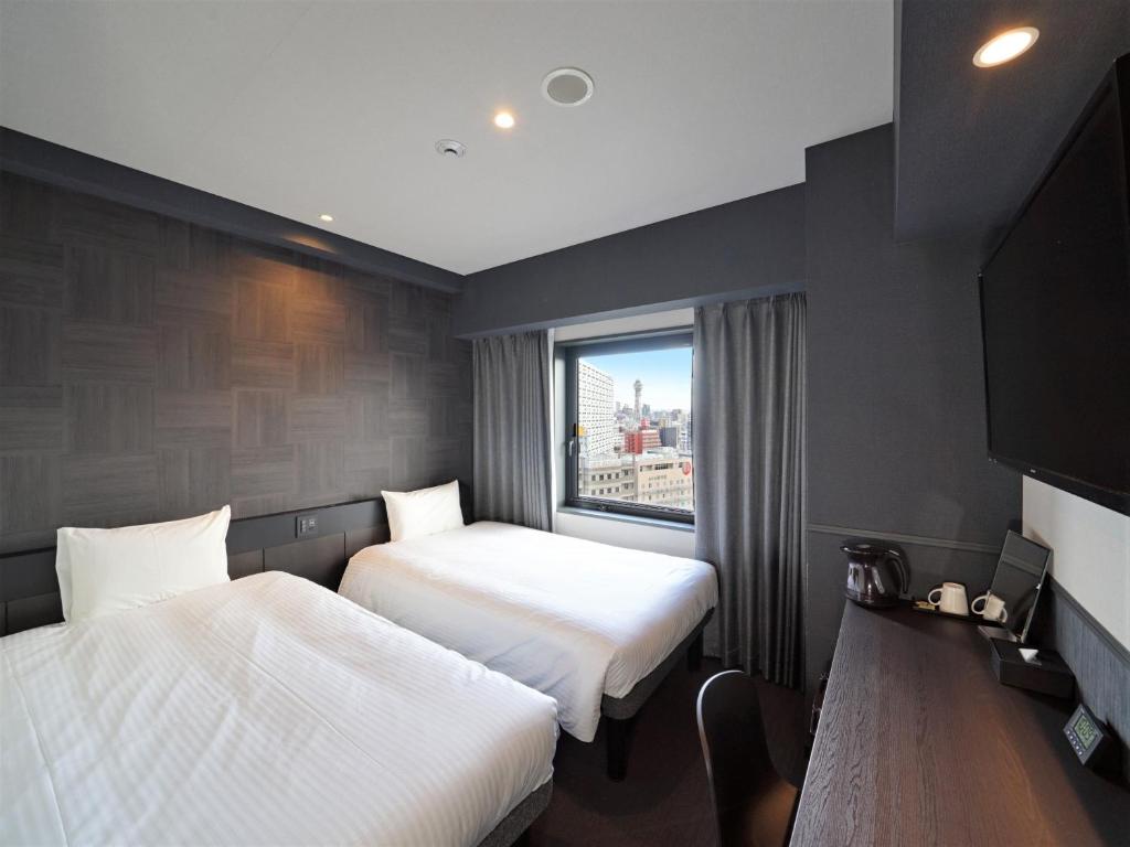 大阪CHISUN STANDARD Osaka Shin-Imamiya的酒店客房设有两张床和窗户。