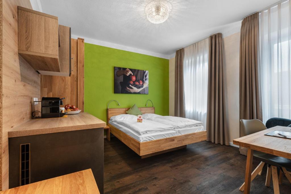 维德宁Schieners Hotel & Apfelhof Apartments的酒店客房配有一张床铺和一张桌子。