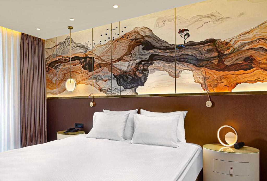 伊斯坦布尔The G Hotels Istanbul的卧室配有一张床,墙上挂着一幅大画