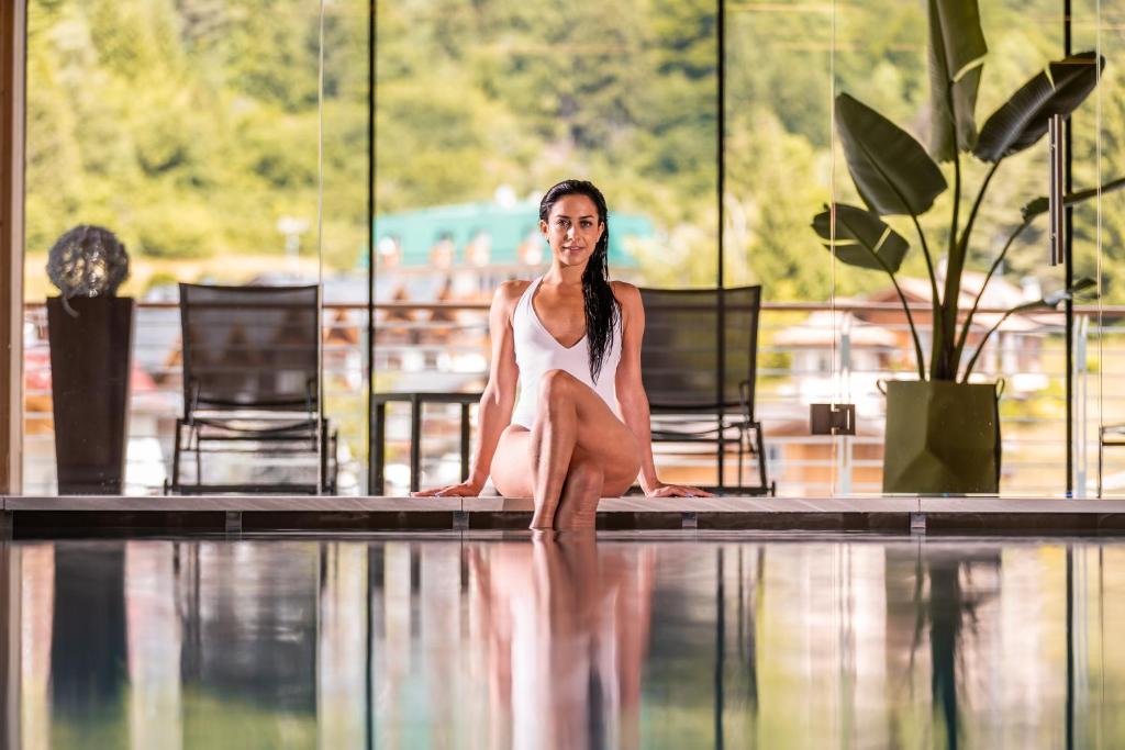 安达洛科罗纳多洛米蒂酒店的坐在游泳池旁的女人