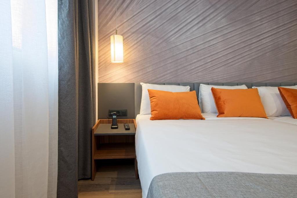 马德里DWO Yuste Alcalá的一间卧室配有一张带橙色枕头的大床