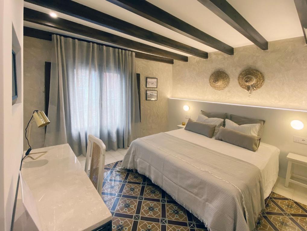 卡瓦内斯Terra i Mar的一间卧室配有一张床、一张桌子和一张书桌