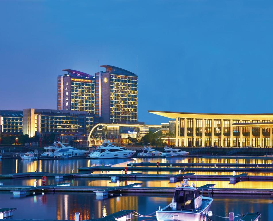 青岛青岛海尔洲际酒店（奥林匹克帆船中心内）的一群船停靠在港口,有建筑物
