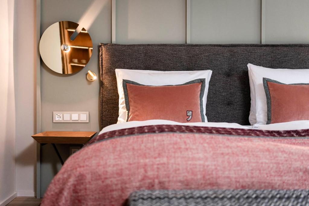 萨尔巴赫伊娃村酒店的一间卧室配有一张带红色毯子和镜子的床