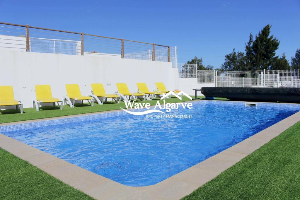 马林堡Villa Salinas in Castro Marim By Wave Algarve的一个带椅子的草地游泳池