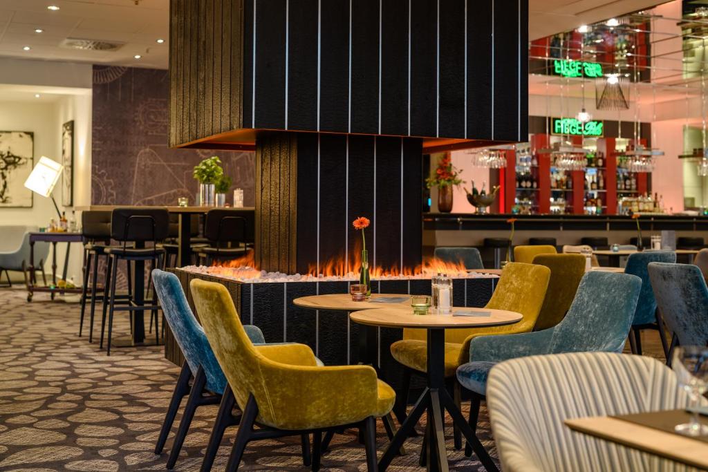 波鸿波鸿市美居酒店的一间带桌椅的餐厅和一间酒吧