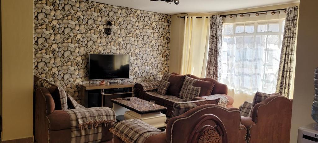 内罗毕Ree homestay and safaris -JKIA的带沙发和电视的客厅