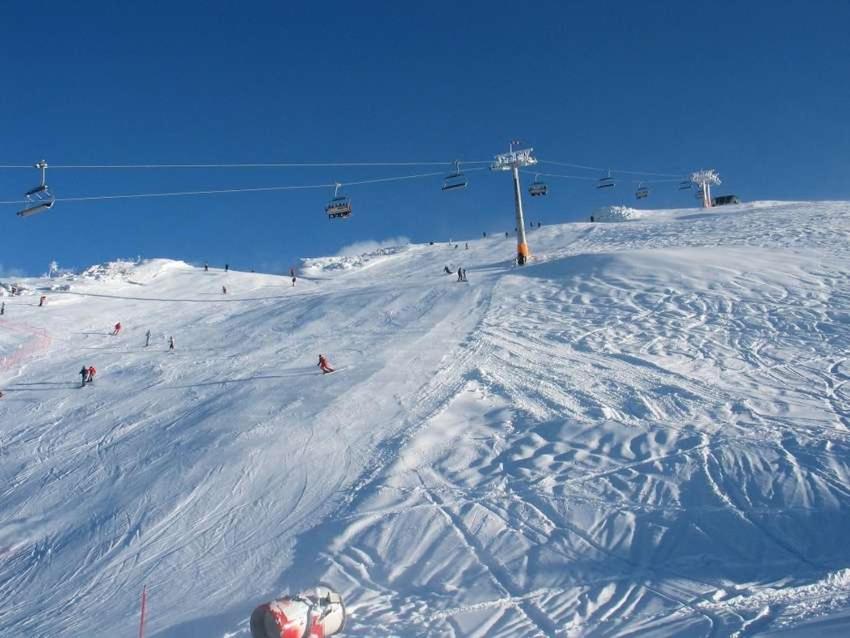 戈雷尼斯卡地区采尔克列Koča pri Binci的一群人沿着雪覆盖的滑雪场滑雪