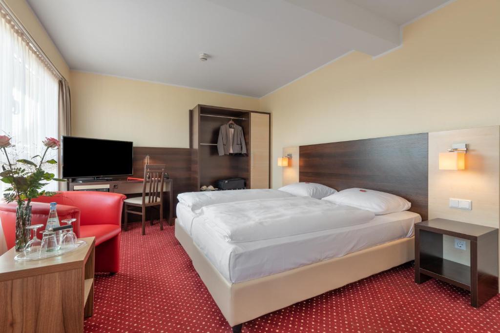 柏林acom Hotel Berlin City Sued的配有一张床和一张书桌的酒店客房
