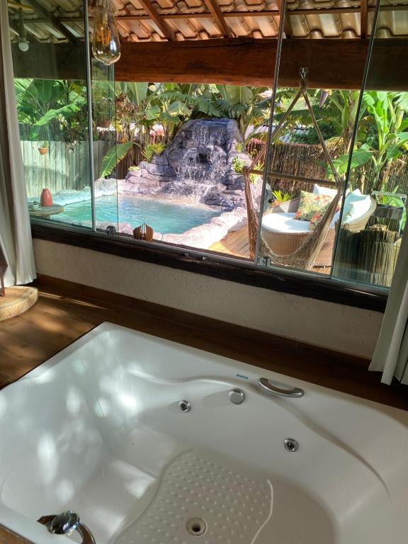 西波山Loft Mandalua的带浴缸的浴室,享有泳池美景