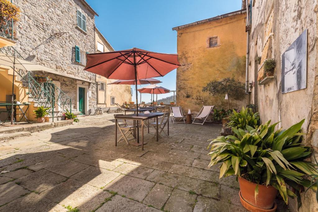 日科德尔格尔福迪艾斯Corte Paganini Casa Vacanze的一个带桌子和遮阳伞的庭院