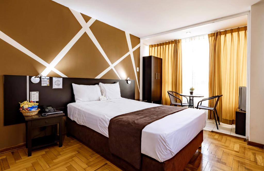 特鲁希略El Centurión的酒店客房设有一张大床和一张桌子。