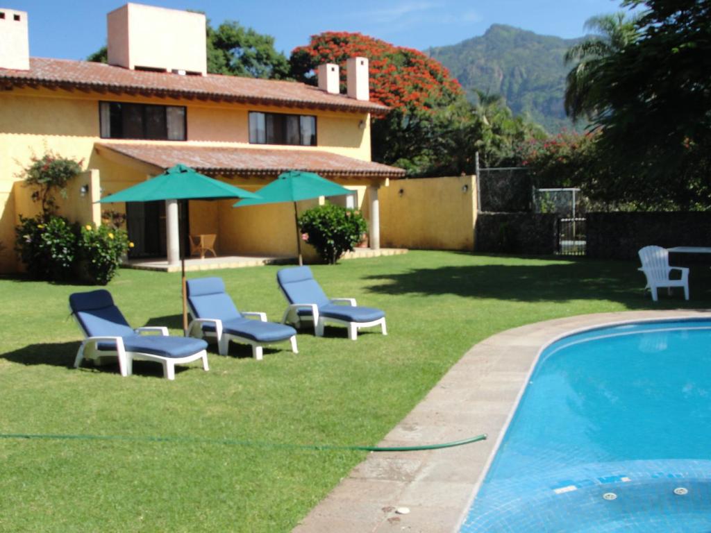 迪坡斯特兰迪坡斯特兰城拉斯卡西塔斯酒店的一个带椅子的庭院、一个游泳池和一个房子