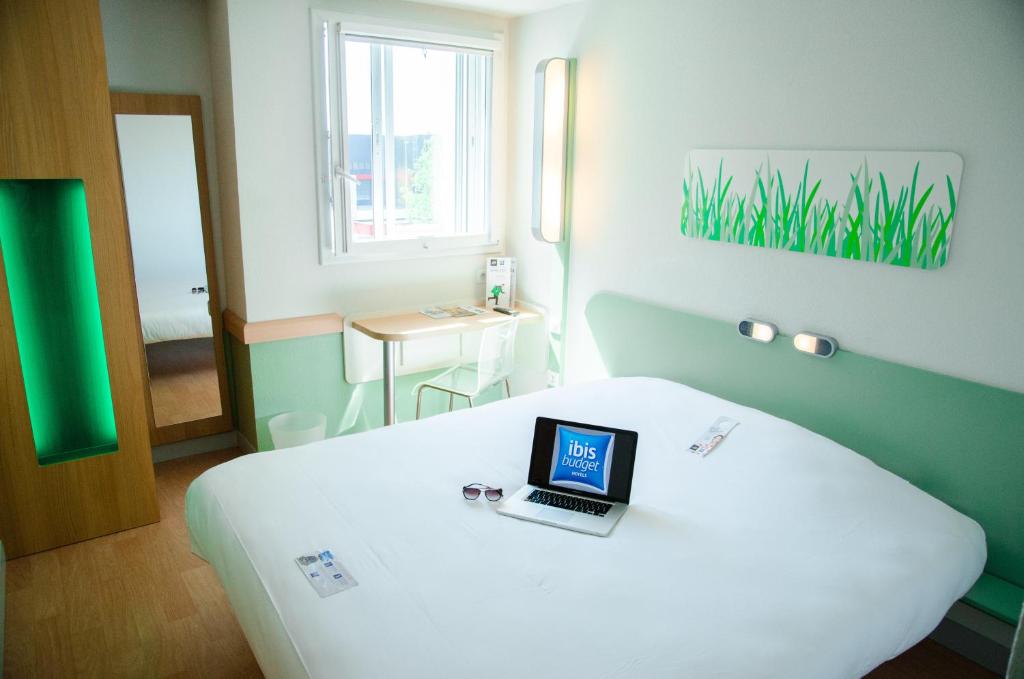 勒布朗-梅尼尔盖和纳巴黎勒布尔热机场宜必思快捷酒店的一间设有床铺的房间,上面有一台笔记本电脑