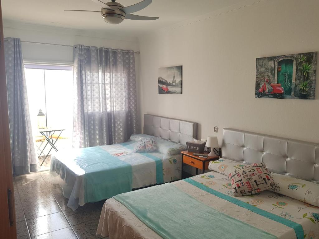 Playa del BurreroApartment & Beach breakfast free的一间卧室配有两张床和吊扇