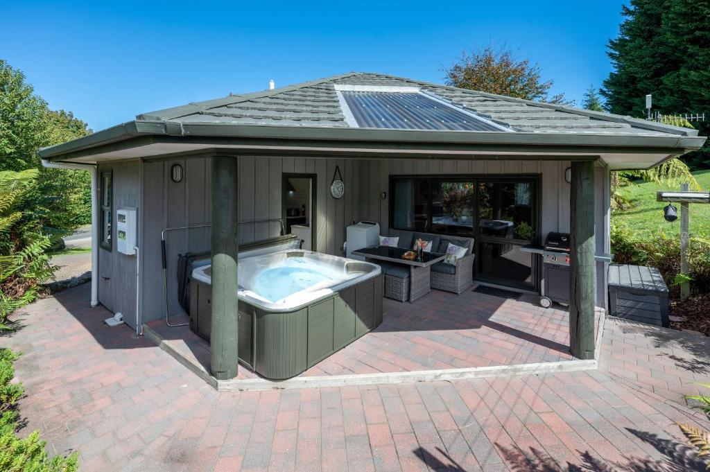 陶波Acacia Heights - Garden Cottage - Taupo的露台的凉亭设有热水浴池
