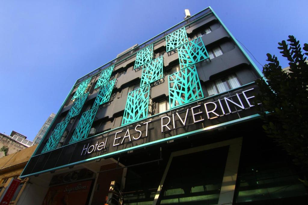 吉隆坡East Riverine Boutique Hotel的一座建筑物,上面有标志,上面写着酒店东边的河滨