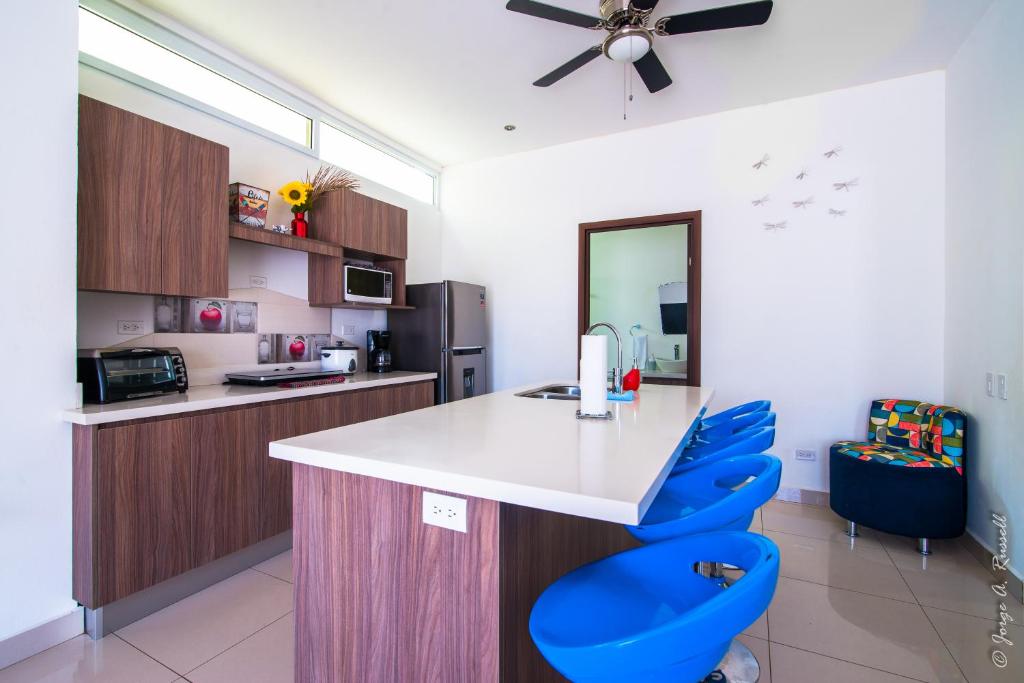 雅科Jaco Modern & Beach Apartment - Lapa Living A1的厨房配有白色的柜台和蓝色的椅子