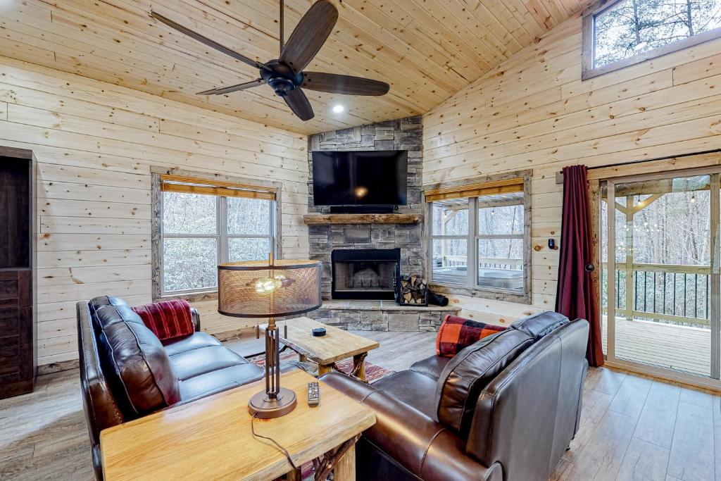 索蒂纳科奇Cozy Bear Cabin #1的客厅配有皮革家具和壁炉