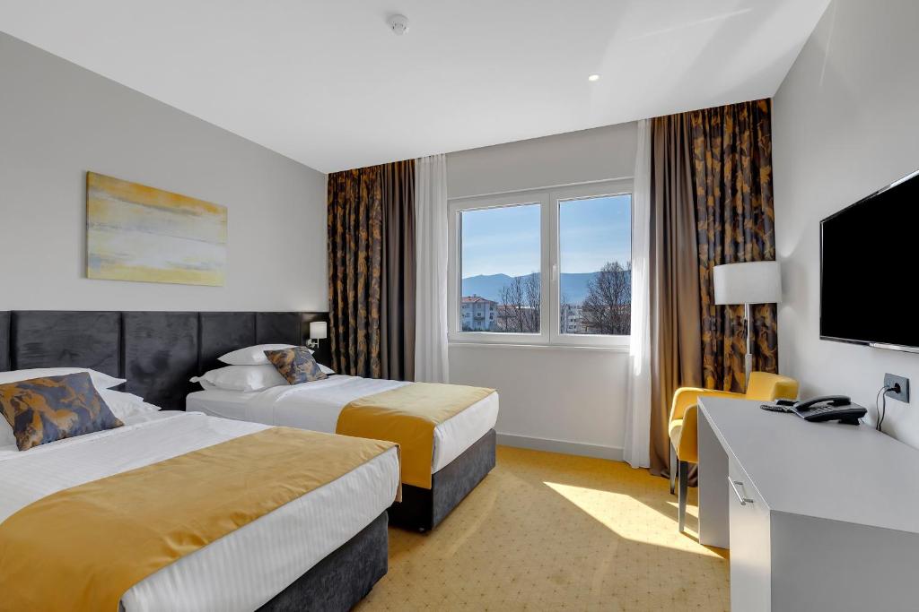 默主歌耶马可尼酒店的酒店客房设有两张床和电视。