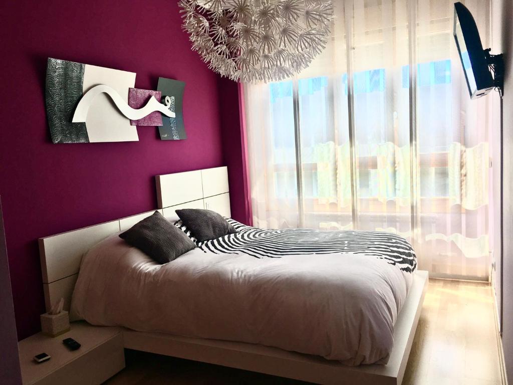 布尔戈斯Burgos Rachel Swim & Paddle的一间卧室设有紫色墙壁、一张床和一个吊灯。